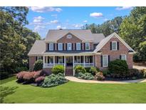 Charming brick home with a welcoming front porch and well-manicured landscaping at 4759 Highland Point Dr, Auburn, GA 30011
