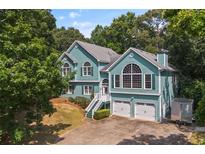 Charming two-story home boasts a two-car garage, well-maintained yard, and inviting staircase leading to the entrance at 533 Coolsprings Walk, Woodstock, GA 30188