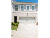 Traditional-style townhome featuring a two-car garage, neutral paint, and a well-maintained lawn at 3374 Verdi Ln, Kennesaw, GA 30144