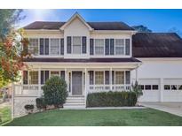 Charming two-story home featuring a well-manicured front yard, a welcoming porch, and an attached two-car garage at 162 Camden Woods Dr, Dallas, GA 30157