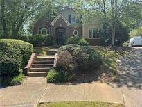 Charming two-story home with mature trees and classic brick accents, enhancing curb appeal at 4504 Allen Hollow, Suwanee, GA 30024