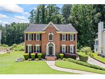 Charming brick home boasts a manicured lawn, black shutters, and a welcoming front entrance at 2500 Ashbourne Dr, Lawrenceville, GA 30043