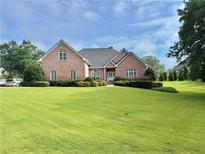 Charming brick home featuring a beautifully landscaped front yard with lush green grass at 3580 Canon Creek Dr, Cumming, GA 30041