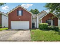Charming brick and vinyl home with a two-car garage and well-maintained lawn at 876 Ashton Oak Cir, Stone Mountain, GA 30083