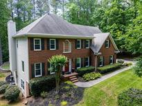 Charming two-story brick home with black shutters, lush landscaping, and a well-manicured front yard at 4673 Jefferson Township Pl, Marietta, GA 30066