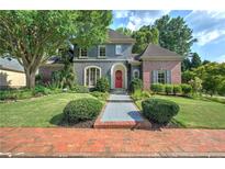 Charming home exterior featuring mature landscaping, inviting entryway, and a red front door at 2160 Kensington Gates Nw Dr, Kennesaw, GA 30152