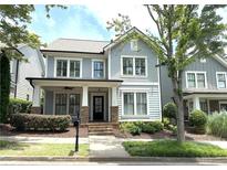 Charming two-story home with a welcoming front porch, lush landscaping, and classic architectural details at 3871 Portland Trail Dr, Suwanee, GA 30024