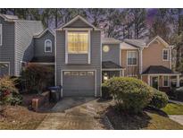Charming two-story townhome featuring a one-car garage and well-maintained landscaping at 1221 Overton Dr, Lawrenceville, GA 30044