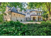 Stunning brick home with manicured landscaping, three car garage, and covered front porch at 1412 Lanier Ne Mnr, Atlanta, GA 30319