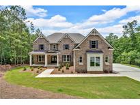 Charming two-story brick home featuring a covered porch and landscaped front yard at 7449 Waterview Cv, Douglasville, GA 30135
