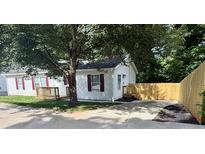 Charming single-story home with a well-manicured lawn and red shutters, shaded by a mature tree and a fenced-in backyard at 1090 Coleman Sw St, Atlanta, GA 30310