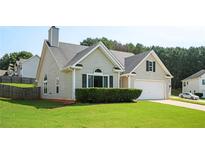 Charming home with neutral siding, well-manicured lawn, and an attached two-car garage at 4776 Harrod Ct, Douglasville, GA 30135