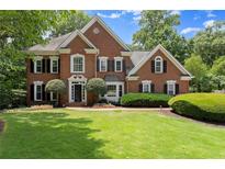 Stately brick two-story home with lush landscaping and manicured lawn at 15 Vickwood Court Ne, Marietta, GA 30068