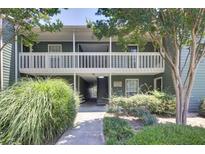 Inviting two-story condo featuring green siding, white railings, and a beautifully landscaped walkway leading to the entrance at 4604 Vinings Central Se Run # 131, Atlanta, GA 30339