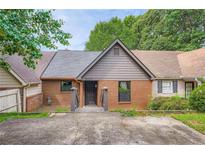 Charming townhouse exterior with a brick facade, gray siding, and well-defined entryway at 2027 Jebs Nw Ct, Kennesaw, GA 30144