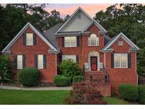 Charming two-story brick home with a well-manicured lawn and inviting front porch at 10119 Azalea Dr, Covington, GA 30014