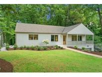 Charming single-story home with a well-manicured lawn and beautiful landscaping at 4103 Statewood Ne Rd, Atlanta, GA 30342