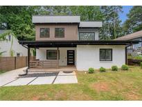 Modern two-story home featuring a painted white brick facade, a covered front porch and contemporary design at 1355 Lockwood Sw Dr, Atlanta, GA 30311