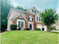Charming two-story home with brick facade, landscaped yard, and a well-manicured lawn at 5771 Vinings Retreat Sw Way, Mableton, GA 30126