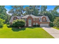 Beautiful brick home with mature trees and lush green lawn at 5148 Coolamber Dr, Powder Springs, GA 30127