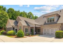 Charming brick home featuring manicured landscaping, attached garage, and classic architectural details at 6042 Brookhaven Cir # 3202, Johns Creek, GA 30097
