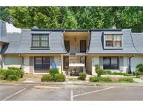 Charming townhouse with well-maintained landscaping, accessible parking, and covered entry, showcasing a cozy residential appeal at 68 La Rue Nw Pl, Atlanta, GA 30327