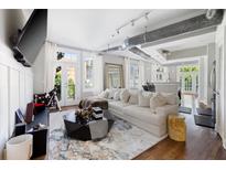 Bright, open living room with hardwood floors and exposed ductwork, filled with natural light from the french doors at 1029 Piedmont Ne Ave # 202, Atlanta, GA 30309