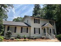 Charming two-story home featuring a classic white facade, black shutters, and a well-manicured front yard at 1789 Springhouse Ct, Lawrenceville, GA 30043