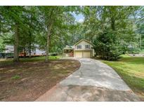 Charming home featuring a long driveway and a welcoming front yard with mature trees at 269 Powder Mill Dr, Dallas, GA 30157