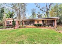 Charming single-story brick home with a lush green lawn and mature trees in a desirable neighborhood at 2994 Baker Ridge Nw Dr, Atlanta, GA 30318