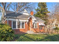 Charming brick home featuring a well-maintained lawn, beautiful landscaping, and a welcoming front entrance at 1015 Deckner Sw Ave, Atlanta, GA 30310