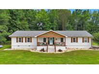 Charming one-story home with a welcoming front porch and a well-manicured lawn and beautiful landscape at 146 Henderson Farm Ln, Canton, GA 30115