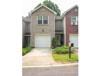 Charming townhome featuring a one-car garage and well-maintained landscaping at 5590 Stonewood Court Ct, Norcross, GA 30093