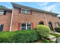 Brick townhouse exterior with red shutters and green landscaping at 6354 Shannon Pkwy # 8B, Union City, GA 30291
