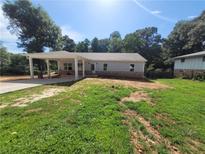 Charming home featuring a covered carport and a well-maintained front yard at 7241 Grayson Dr, Riverdale, GA 30296