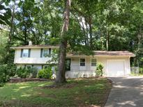 Traditional two-story home with a lush green lawn and mature trees providing shade at 5512 Arrowhead Dr, Acworth, GA 30102