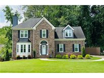 Charming brick home with lush lawn and well-maintained landscaping at 735 Jamie Ne Way, Woodstock, GA 30188