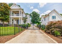 Stunning two-story home featuring a manicured lawn and an elegant gated driveway at 1505 Walker Ave, College Park, GA 30337