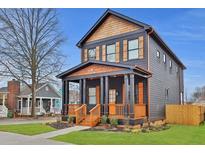 Charming two-story home featuring a welcoming front porch, dark siding, and cedar accents at 701 Smith St, Atlanta, GA 30310