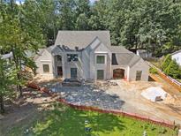 Elegant home featuring light brick, a covered portico, and a meticulously landscaped area, exuding timeless charm at 141 N. Trace, Alpharetta, GA 30009