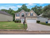 Charming two-story home featuring a well-maintained lawn and a two-car garage at 2210 Benidorm Ct, South Fulton, GA 30349