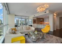 Bright living room with modern lighting fixture, white sectional, and floor-to-ceiling windows at 3325 Piedmont Ne Rd # 2501, Atlanta, GA 30305