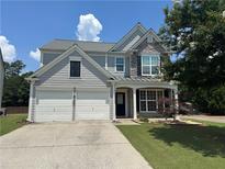 Charming two-story home featuring a two-car garage and a stone-accented facade at 8965 Friarbridge Dr, Suwanee, GA 30024