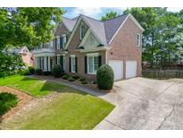 Stunning brick two-story home featuring a two-car garage and a beautifully manicured lawn at 1024 Cromwell Pt, Snellville, GA 30078