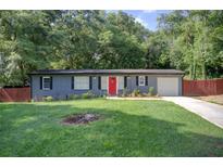 Charming single-story home with a well-maintained lawn, and a bright red front door at 2619 Old Toney Rd, Ellenwood, GA 30294