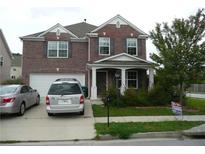 Attractive two-story brick home featuring a covered front porch, well-kept lawn, and two-car garage at 2748 Farmstead Ct, Grayson, GA 30017