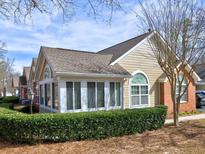 Charming tan and brick home featuring a beautiful sunroom and well-maintained landscaping at 2730 Vintage Reserve Ln, Marietta, GA 30066