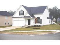 Charming two-story home featuring a manicured lawn and attached two car garage, offering both curb appeal and convenience at 4232 Kensington Cv, Atlanta, GA 30349