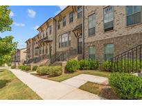 Beautiful brick townhomes with manicured landscaping and inviting walkways at 613 Harrington Hls, Decatur, GA 30032