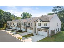 Charming townhomes with two-car garages, neutral colors, and tasteful brick and siding accents in a well-maintained community at 1317 Aura Ln, Lawrenceville, GA 30045